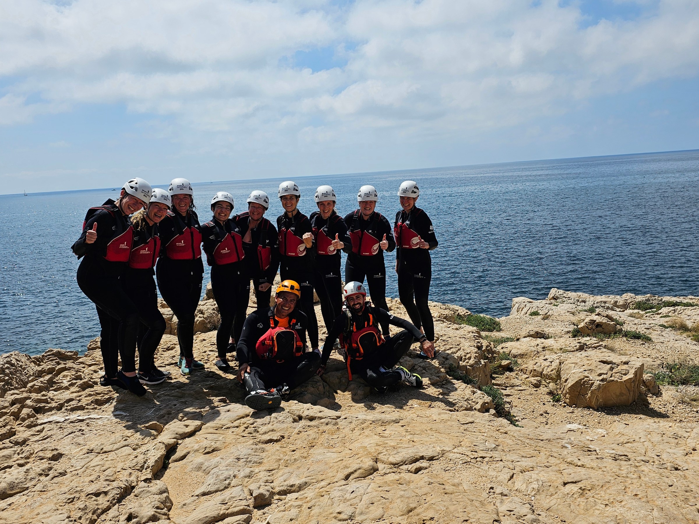 a group of people standing on a rocky beach