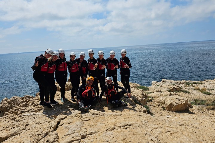 a group of people standing on a rocky beach