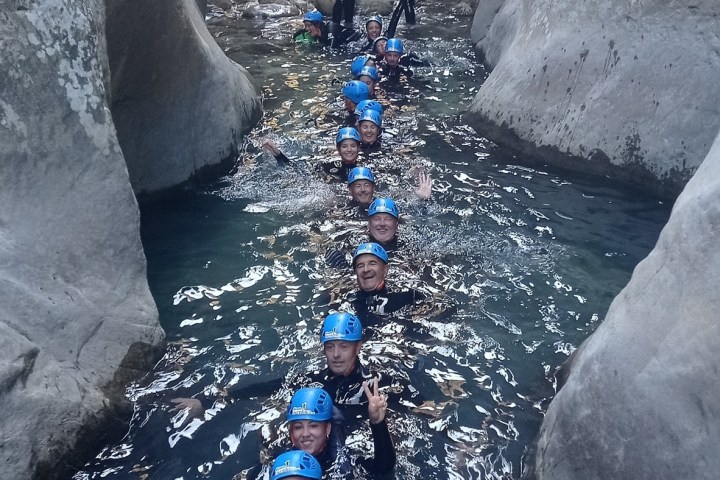 a man standing in front of a large rock
