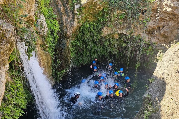 a large waterfall next to a rock