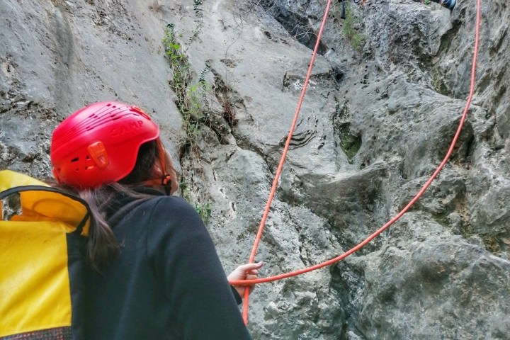 a person standing next to a rock wall