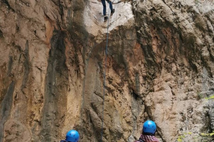 a couple of people that are standing in a rocky area