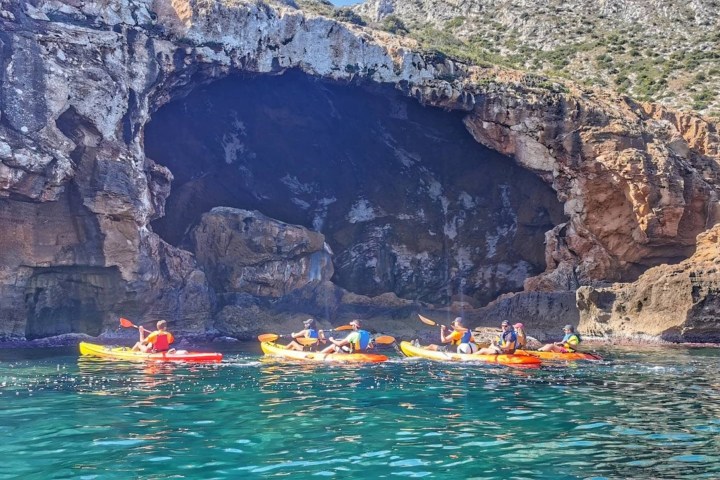 a small boat in a body of water with a mountain in the background