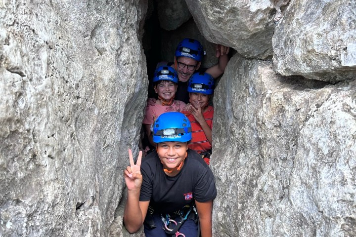 a man standing in front of a large rock