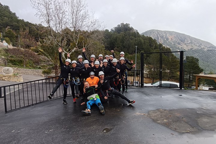 a group of people sitting on a bench in front of a mountain road