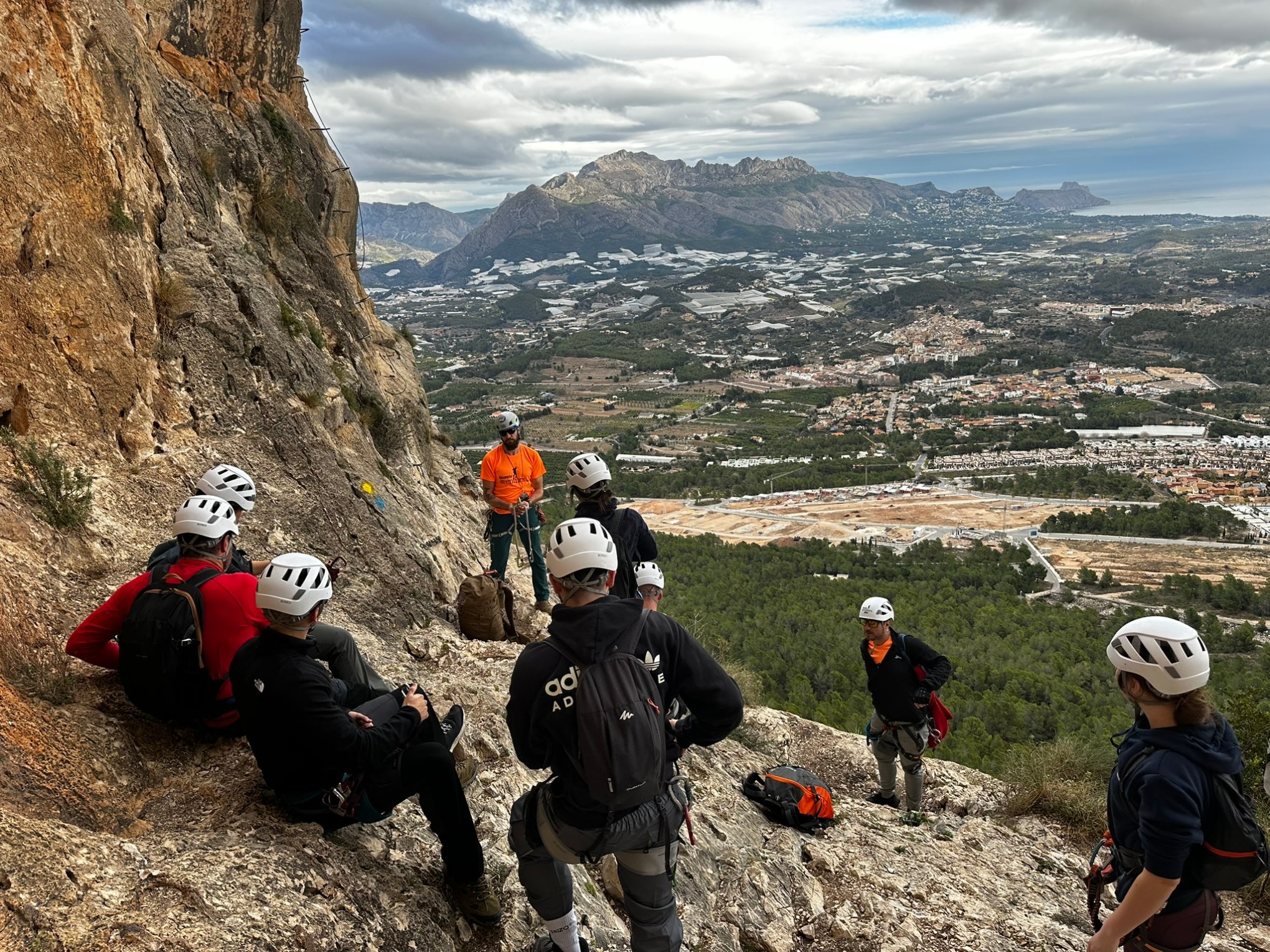 a group of people sitting on the side of a mountain