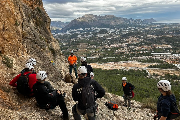 a group of people sitting on the side of a mountain