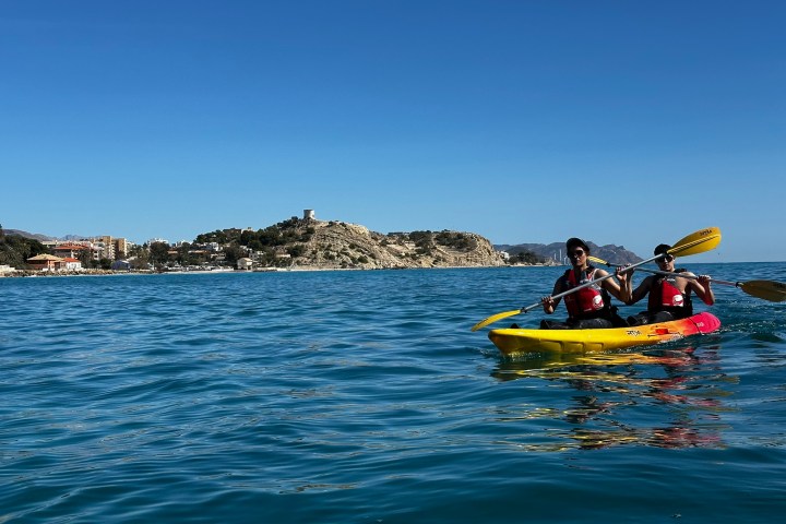 a group of people riding on the back of a boat in the water