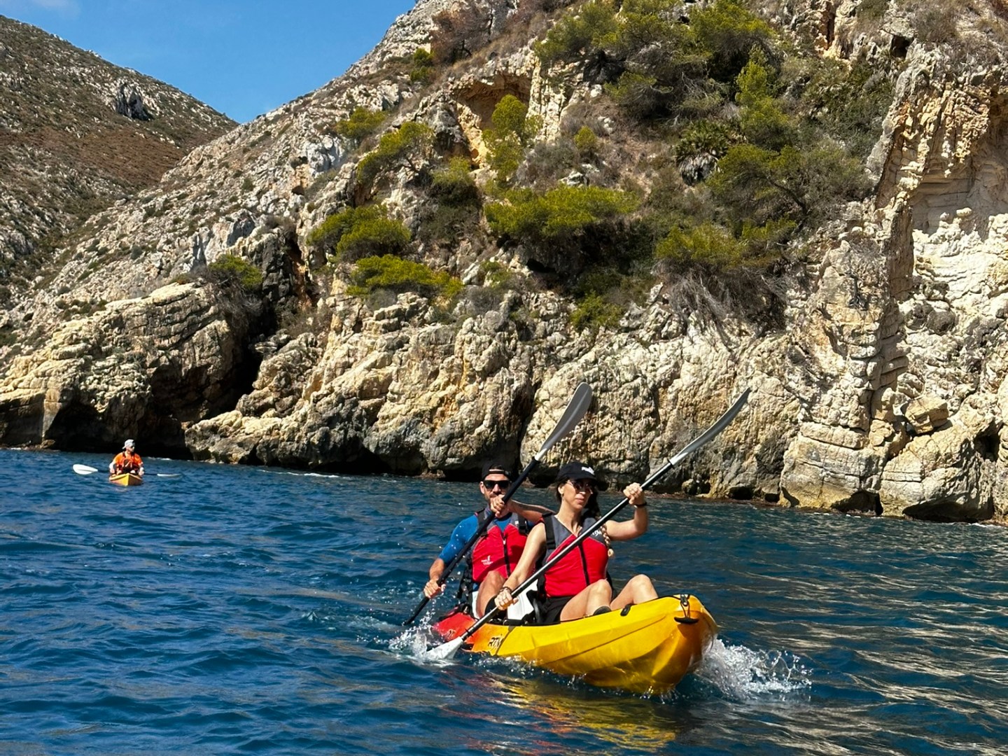 a group of people riding on the back of a boat in the water