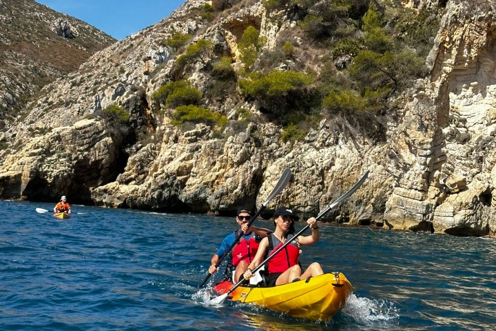 a group of people riding on the back of a boat in the water