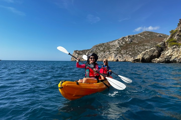 a man riding on the back of a boat in the water