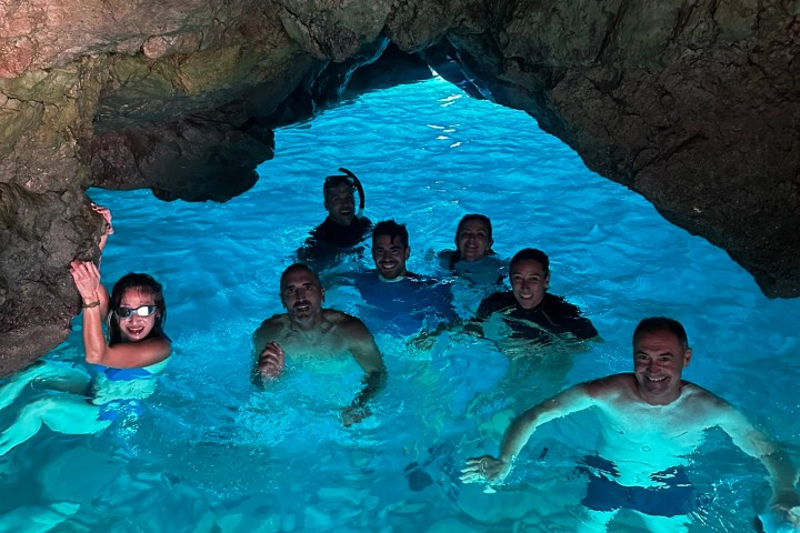 a group of people swimming in a rocky area