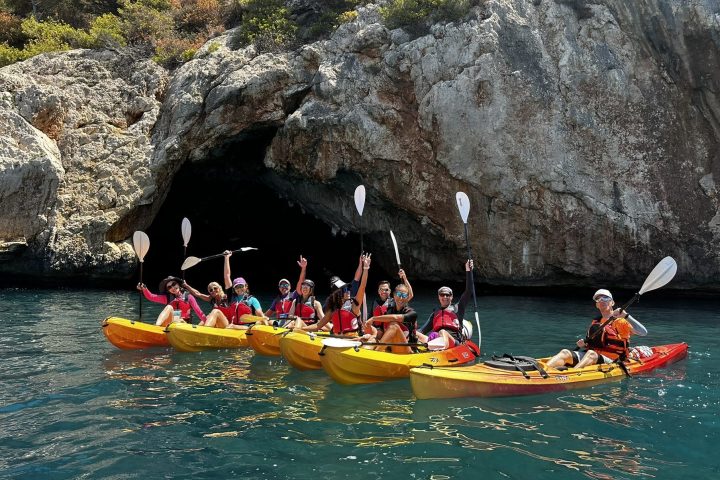 a group of people riding on the back of a boat in the water