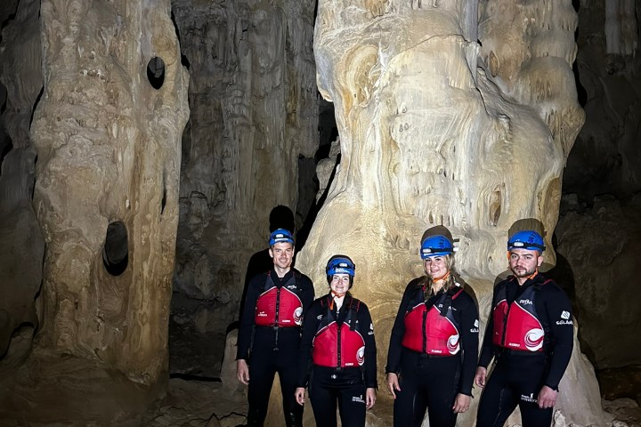 a group of people standing next to a stone wall