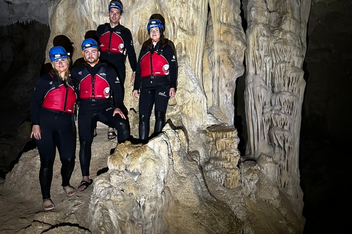 a group of people standing next to a stone wall