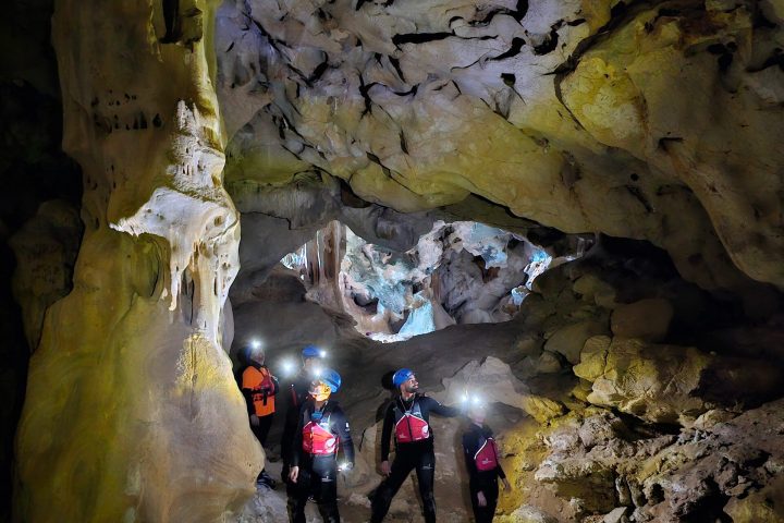 a group of people standing next to a waterfall