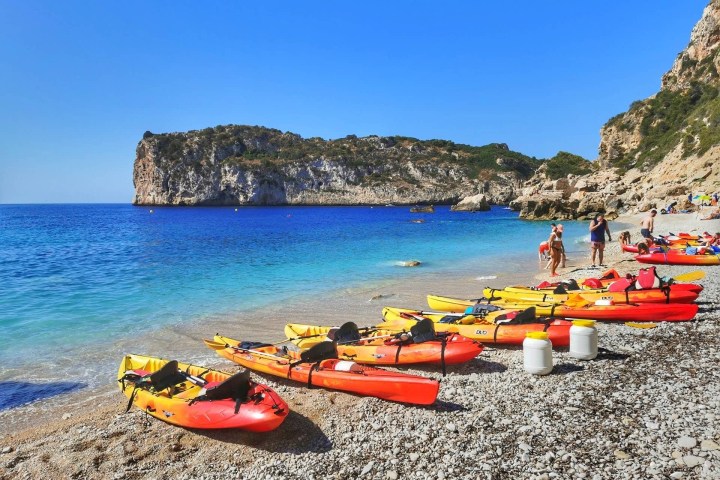 a row of colorful umbrellas sitting next to a body of water