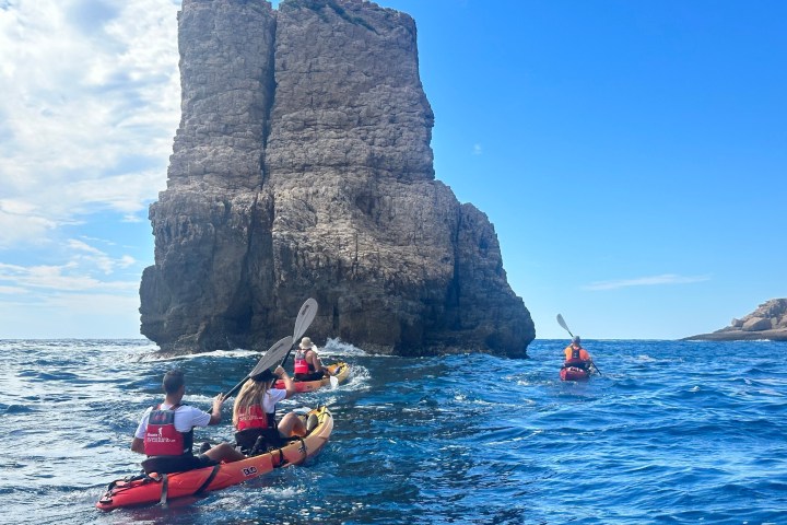 a small boat in a body of water with a mountain in the background