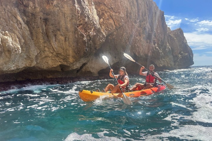 a group of people riding on the back of a boat in the water