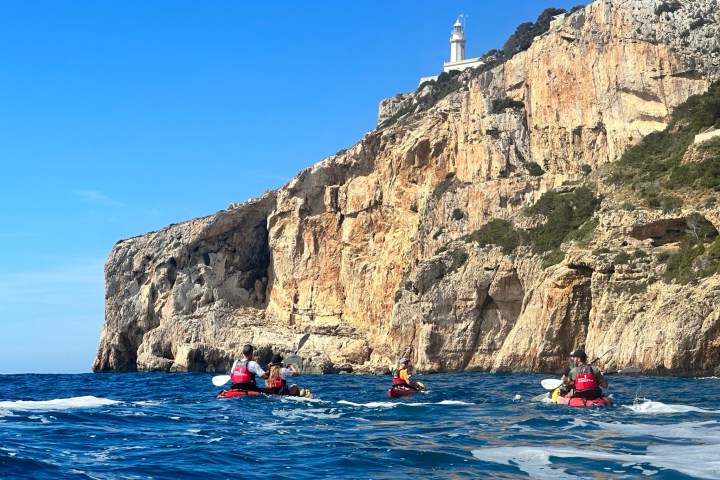 a small boat in a body of water with a mountain in the background