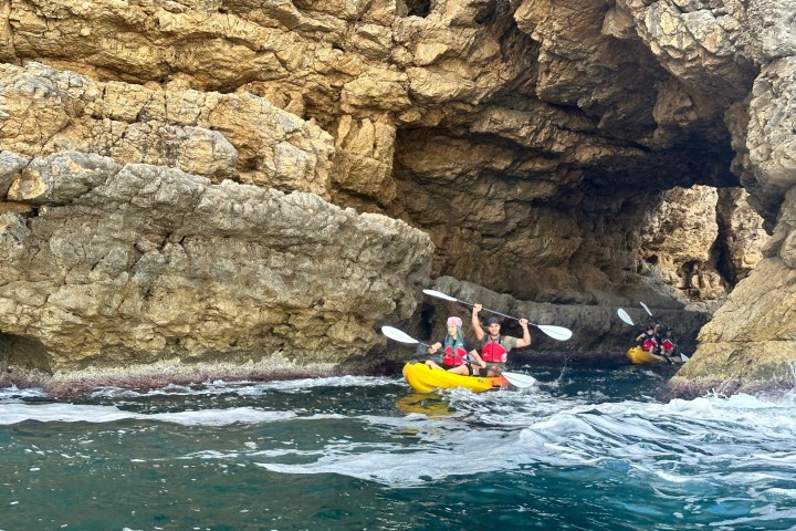a group of people on a rock next to water