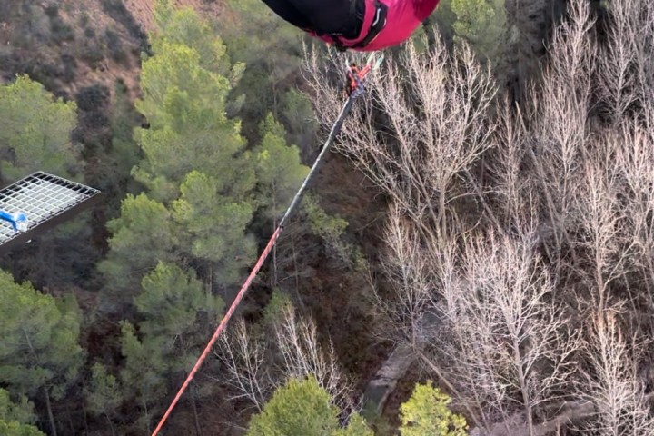 a person flying through the air in front of a forest