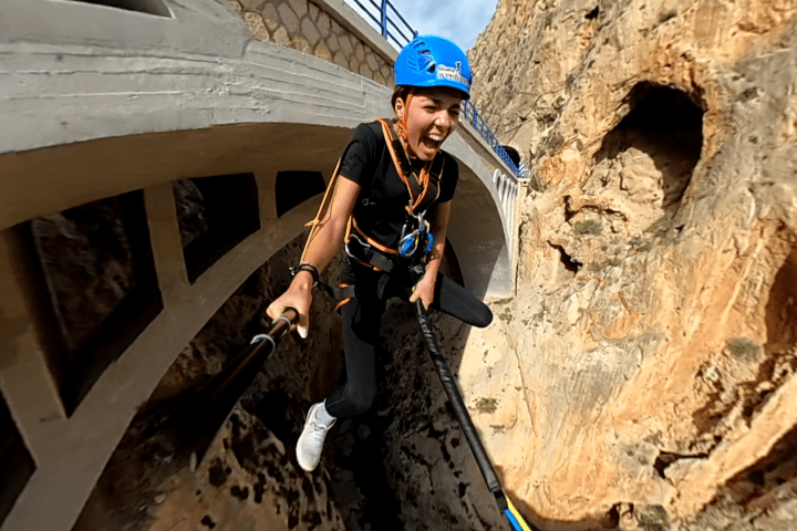 a man standing next to a stone wall