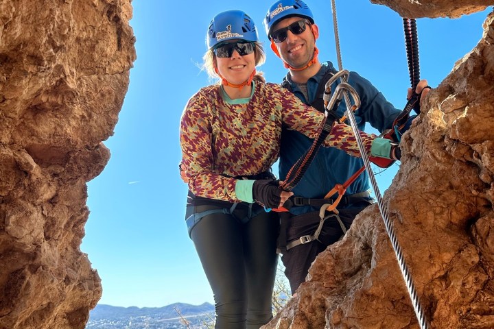 a person standing in front of a large rock