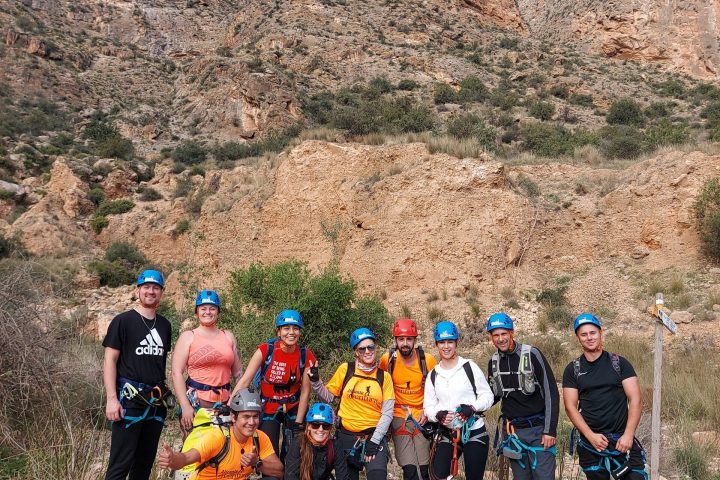 a group of people standing in front of a mountain