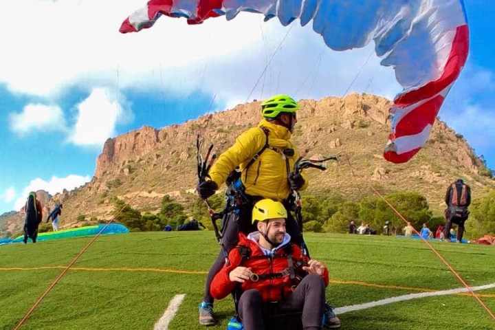 a group of people flying kites in a field