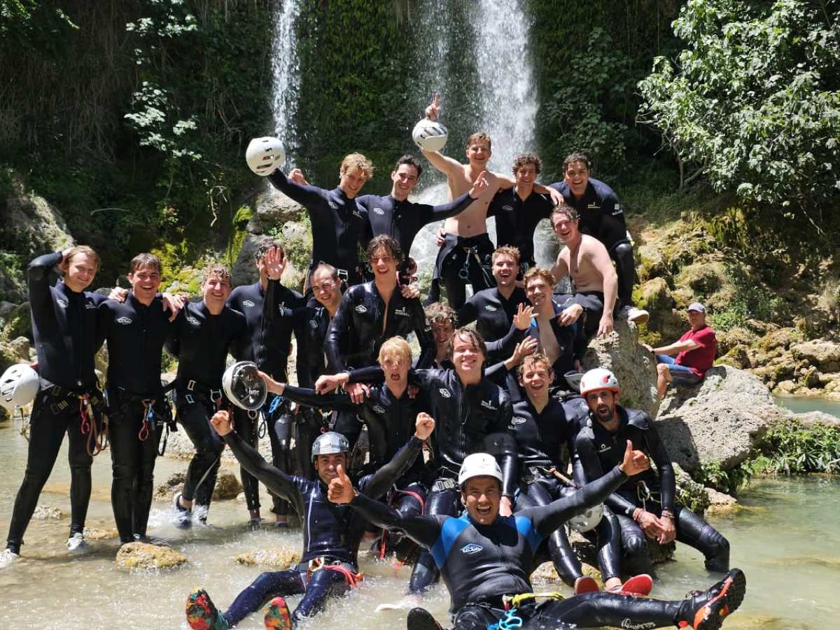 a group of people standing next to a river