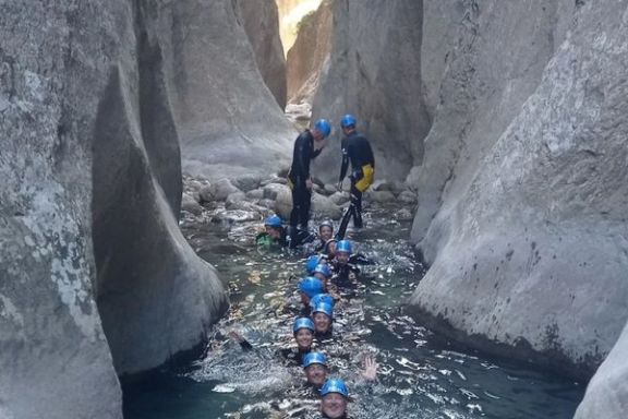 Grupo de barranquistas junto a una pequeña cascada en el Estret de les Penyes
