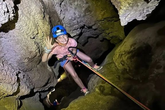 Participante descendiendo en rápel por el interior de la Cova Fosca