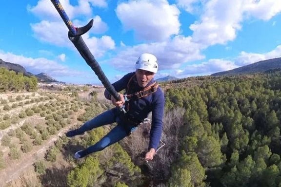 Participante realizando un salto de puenting con el paisaje natural de Alcoy al fondo