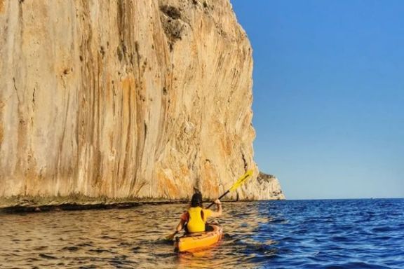Kayak navegando junto a los acantilados del Morro de Toix en la costa de Altea