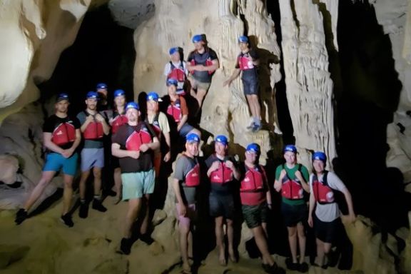 Grupo explorando el interior de la Cova dels Coloms durante la ruta guiada en kayak