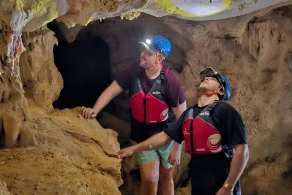 Participantes explorando el interior de la Cova dels Coloms con frontal