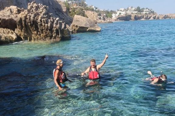 Participantes practicando snorkel en una cala de aguas cristalinas durante la ruta en kayak por las calas de Villajoyosa.