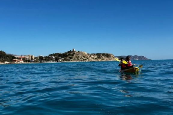 Pareja navegando en kayak frente a la costa de Villajoyosa durante la ruta guiada.