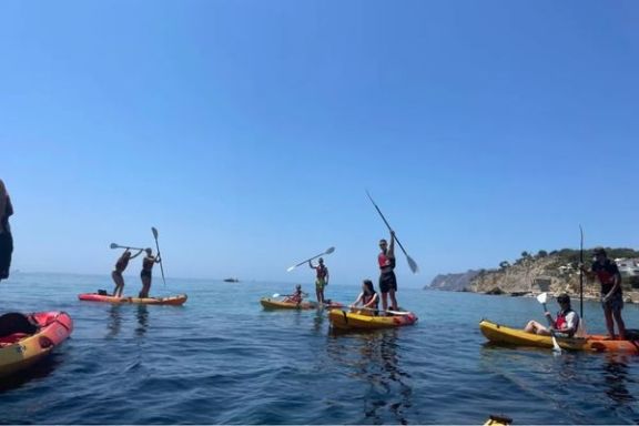 Grupo disfrutando de la ruta en kayak y paddle surf frente a la costa de Moraira