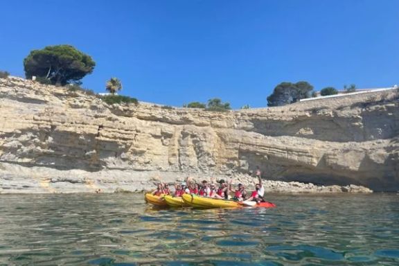 Grupo navegando en kayak junto a los acantilados de Cap Blanc durante la ruta guiada