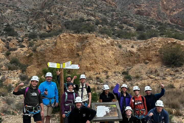 a group of people standing in front of a mountain