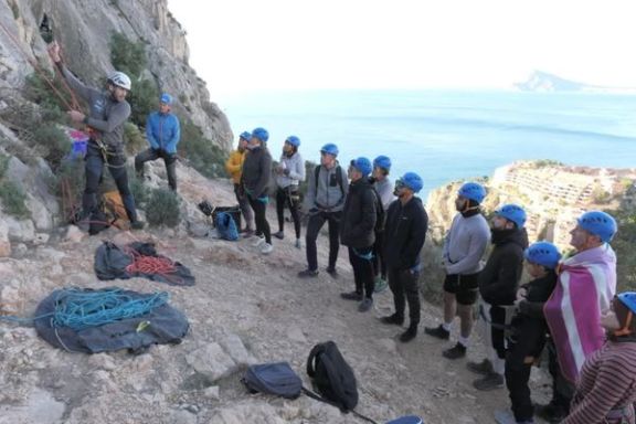 Participantes recibiendo instrucciones de escalada en roca antes de comenzar su bautismo de escalada en Altea.
