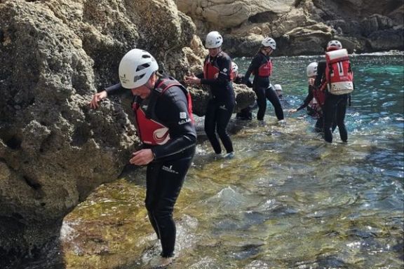 Participantes progresando por la costa rocosa durante una excursión de coasteering