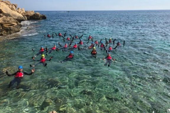 Grupo nadando en aguas transparentes durante una actividad de coasteering en Alicante