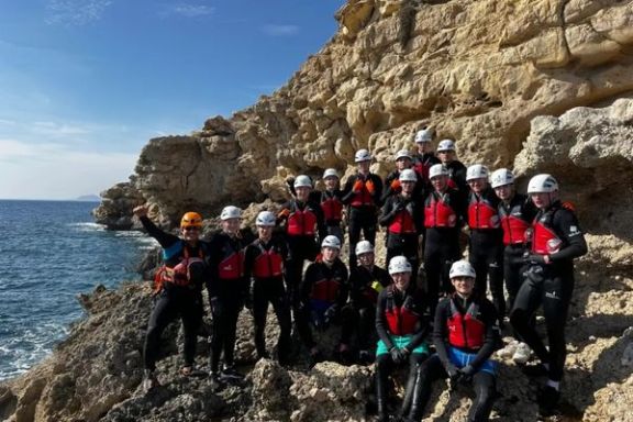 Grupo equipado con neopreno, casco y chaleco durante una ruta de coasteering