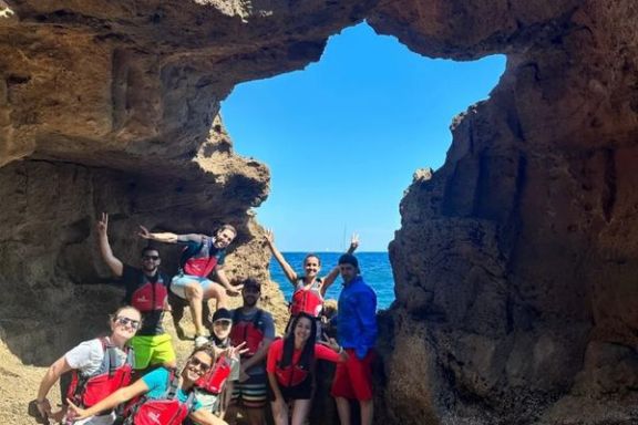 Grupo en la entrada de la Cova Tallada con vistas al mar durante la ruta en kayak