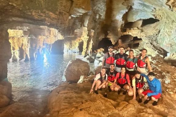 Grupo disfrutando del interior de la Cova Tallada junto a una piscina natural