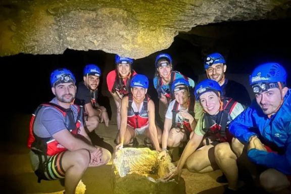 Participantes junto a una antigua pila excavada en la piedra durante la visita a la Cova Tallada