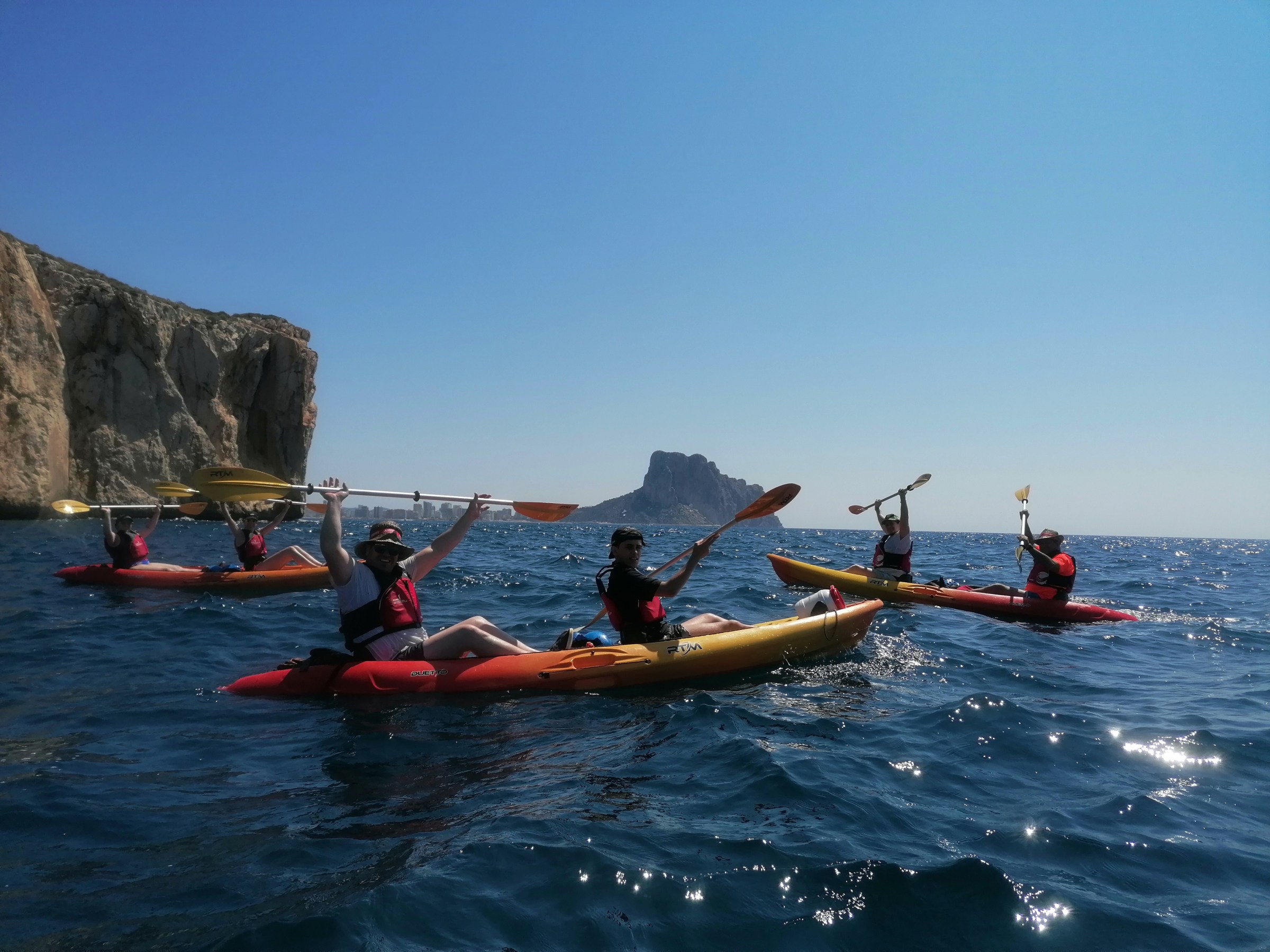 a group of people riding on the back of a boat in the water
